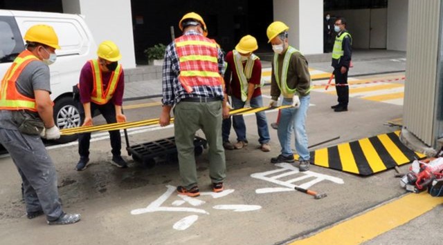 Construction workers cover with a metal plate parts of a painted slogan commemorating the 1989 Tiananmen Square crackdown, along the Swire Bridge at the University of Hong Kong (HKU) in Hong Kong, China January 29, 2022. The Chinese characters read: "cold-blooded". (Reuters)