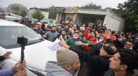Angry over ticket distribution, Aam Admi Party workers try to stop Punjab party co-incharge Raghav Chadha's car, in Jalandhar, Friday. (Photo/PTI)