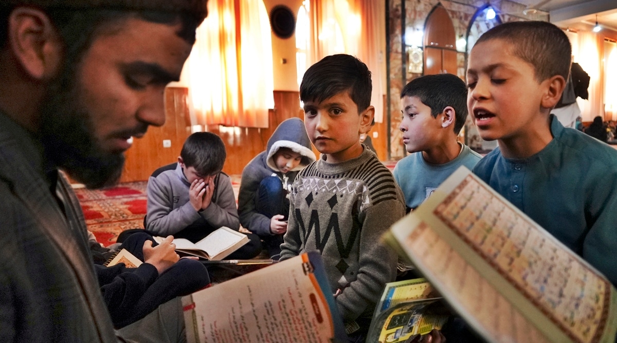 Sanam, a bacha posh -- a girl living as a boy, center, sits among Afghan boys as they read the Quran, Islam's holy book, during a class at a mosque, in Kabul, Afghanistan, Wednesday, Dec. 8, 2021. (AP)