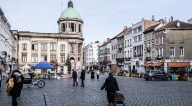People walk through the town square of the Molenbeek neighborhood of Brussels on Dec. 7, 2021. (The New York Times)