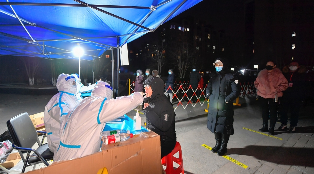 A worker wearing a protective suit swabs for a coronavirus test at a testing site in northern China's Tianjin Municipality, Wednesday, Jan. 12, 2022. (Sun Fanyue/Xinhua via AP)


