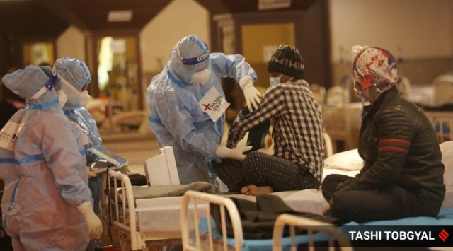 Medical staff attend to admitted Covid-19 patients at the Shenai Banquet quarantine and care centre in New Delhi. (Express Photo by Tashi Tobgyal)