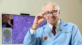 A provided image shows Dr. Ronald Weinstein holding a component of a telepathology imaging system. (Kris Hanning via The New York Times)