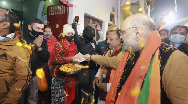 Saharanpur: Union Home Minister Amit Shah distributes pamphlets during his door-to-door campaign ahead of the Uttar Pradesh Assembly elections, at Sharda Nagar in Saharanpur. (PTI Photo)
