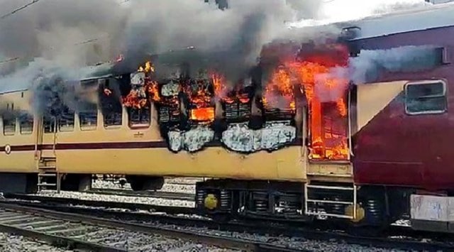 A train burns after the aspirants set it on fire during their protest over alleged erroneous results of Railway Recruitment Boards-Non Technical Popular Categories (RRB-NTPC) exams, at Gaya Junction railway station, Wednesday, January 26, 2022.  (PTI)