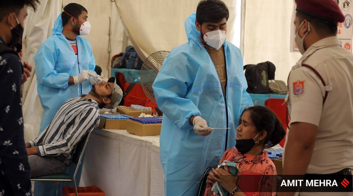 A healthcare worker collects the swab sample of a patient in Bengaluru. 