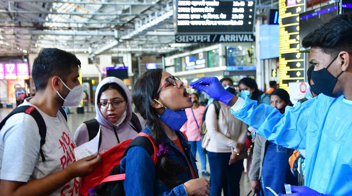 A Brihanmumbai Municipal Corporation (BMC) health worker collects swab sample of an outstation passenger for COVID-19 test at CSMT railway station. (PTI)