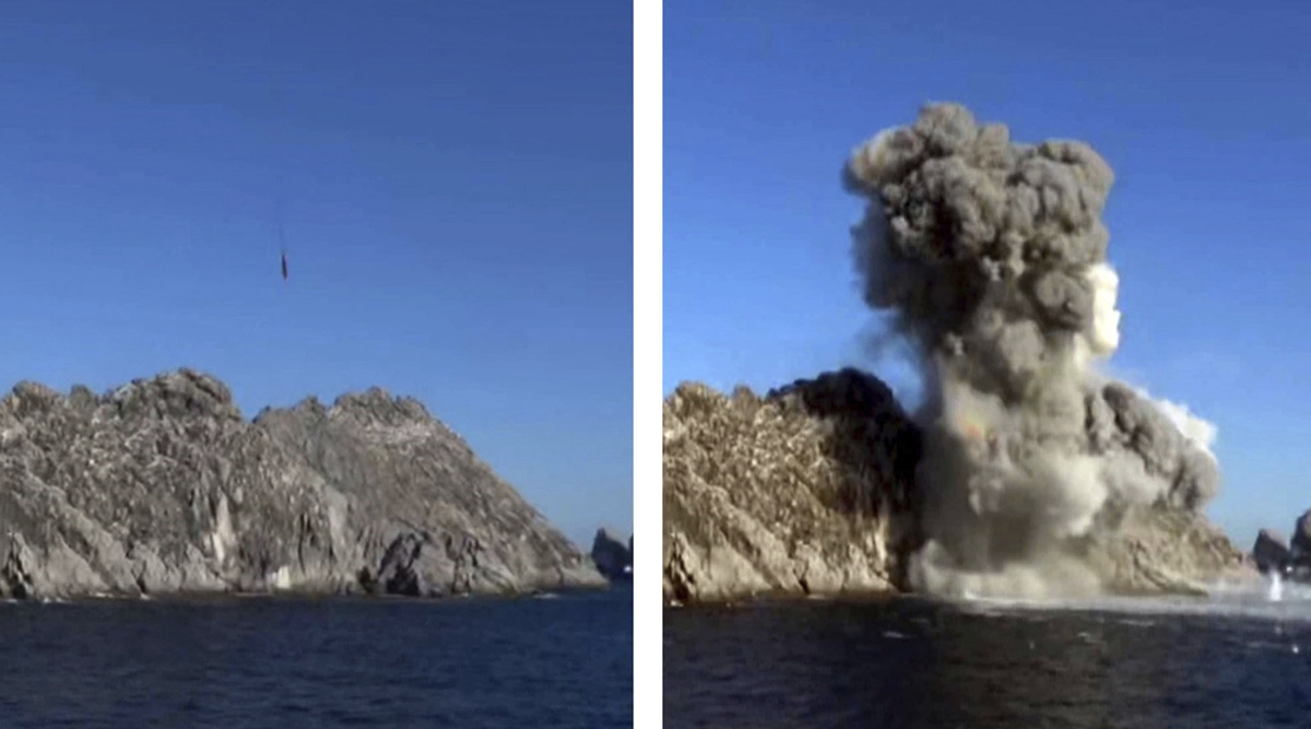A landscape with cliffs and water explodes in a cloud of smoke during a missile test from a train in North Pyongan Province. (Photo: AP)