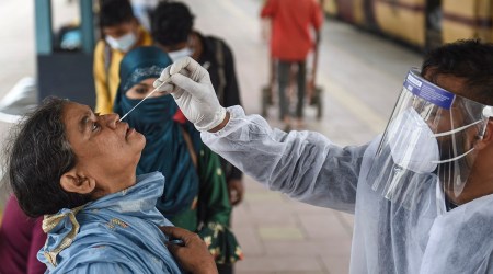 A health worker takes a swab sample of a traveller for Covid-19 testing. (PTI)