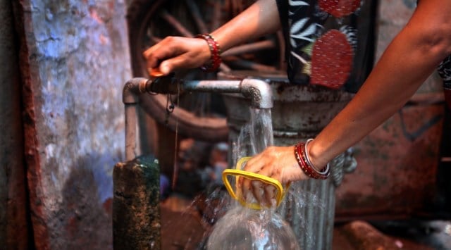 A woman collects water from a tap in Sabzi Mandi area. (Express Photo/File)