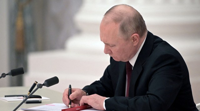 Russian President Vladimir Putin signs documents, including a decree recognising two Russian-backed breakaway regions in eastern Ukraine as independent entities, during a ceremony in Moscow, Russia, in this picture released February 21, 2022. (Reuters)