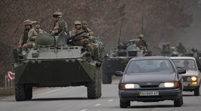 Ukrainian servicemen sit atop armored personnel carriers driving on a road in the Donetsk region, eastern Ukraine, Thursday, Feb. 24, 2022. (AP)