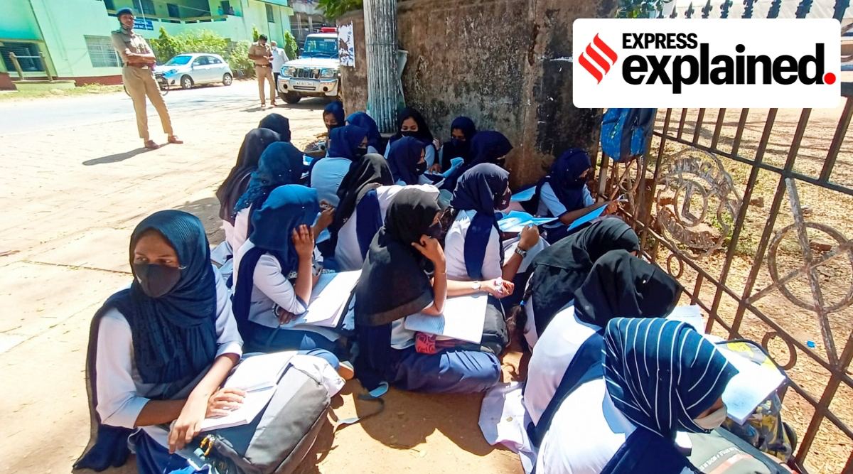 Students sit outside their school in Kundapura village, Karnataka on Friday after the authorities denied them entry for wearing a hijab. (PTI Photo)