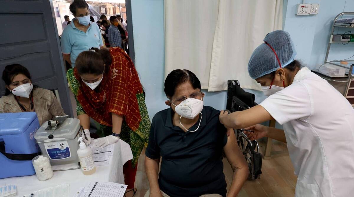 A health worker administering Covid booster dose to a beneficiary at the Rajawadi Hospital in Ghatkopar. (Express photo by Amit Chakravarty)