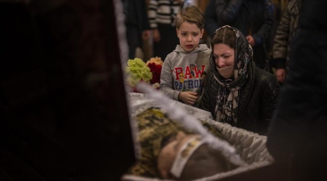 A woman and a boy react next to the body of Ukrainian Army captain Anton Sydorov, 35, killed in eastern Ukraine, during his funeral, in Kyiv, Ukraine, Tuesday, Feb. 22, 2022. (AP)