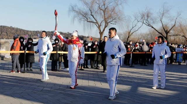 Torch bearer Liu Qingquan carries the Olympic flame at the Summer Palace in Haidian district. (REUTERS)