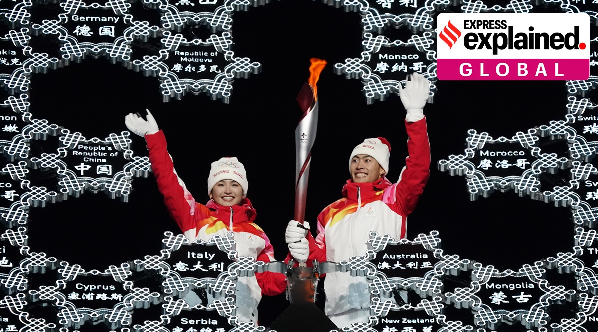 Olympic torch is brought into the stadium by Dinigeer Yilamujian and Zhao Jiawen during the opening ceremony of the 2022 Winter Olympics. (AP)