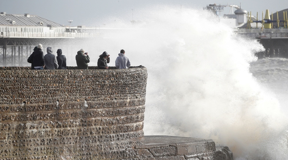  People take pictures as waves break on during Storm Eunice, in Brighton, Britain, February 18, 2022. (Reuters)