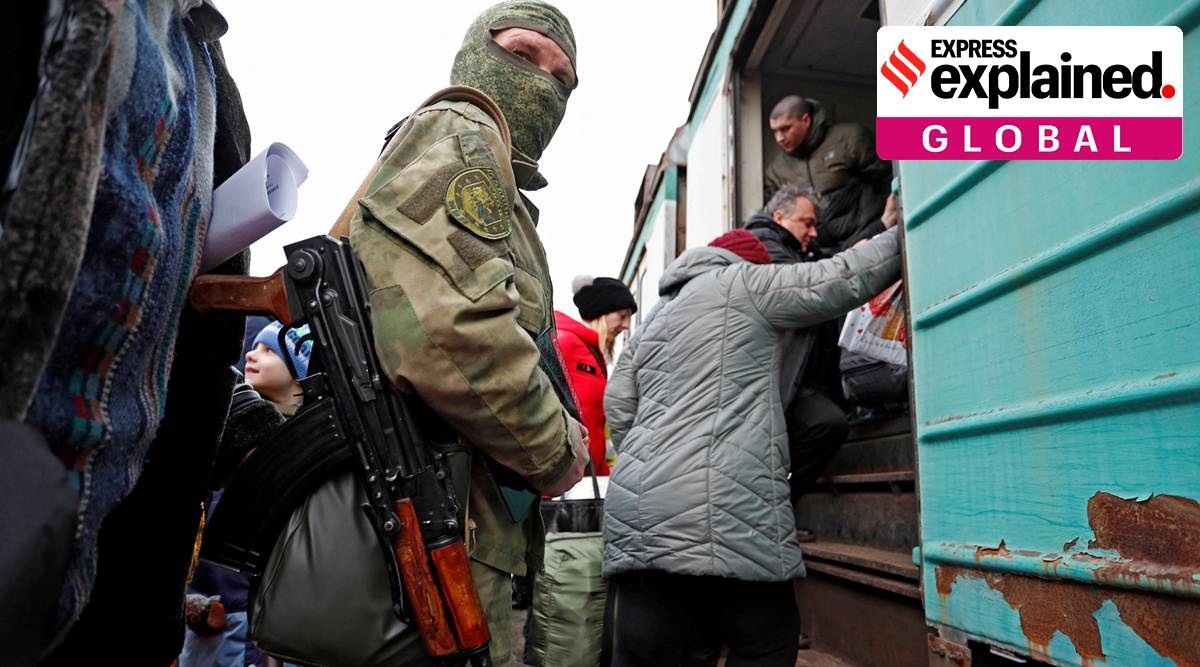 A militant stands at a platform in Donetsk, as evacuees board a train on Wednesday. (Reuters Photo)