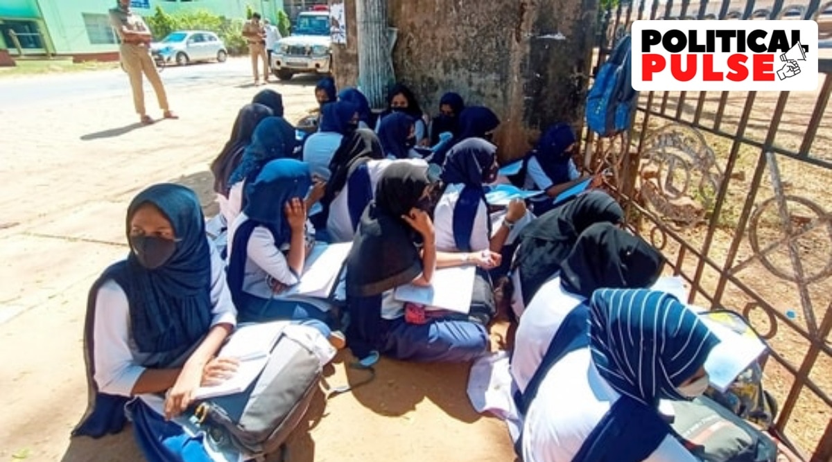 Students sit outside their school in Kundapura village, Karnataka on Friday after the authorities denied them entry for wearing a hijab. (PTI Photo)