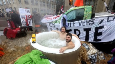 Jean-Philippe and Gabriel, who declined to give their last names, sit in a hot tub, as truckers and their supporters continue to protest coronavirus disease vaccine mandates, in Ottawa, Ontario, Canada, February 17, 2022. (Reuters)