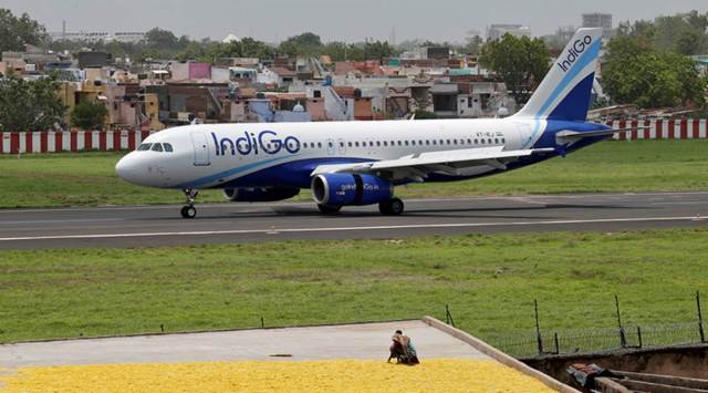Women spread fryums for drying on a rooftop as an IndiGo Airlines Airbus A320-200 aircraft moves on the runway after landing at the Sardar Vallabhbhai Patel international airport in Ahmedabad, India July 6, 2017. (REUTERS/File Photo)