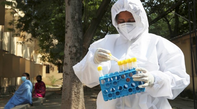 A health worker checks swab samples collected for RTPCR test to detect COVID-19 at a government hospital. (File/AP)