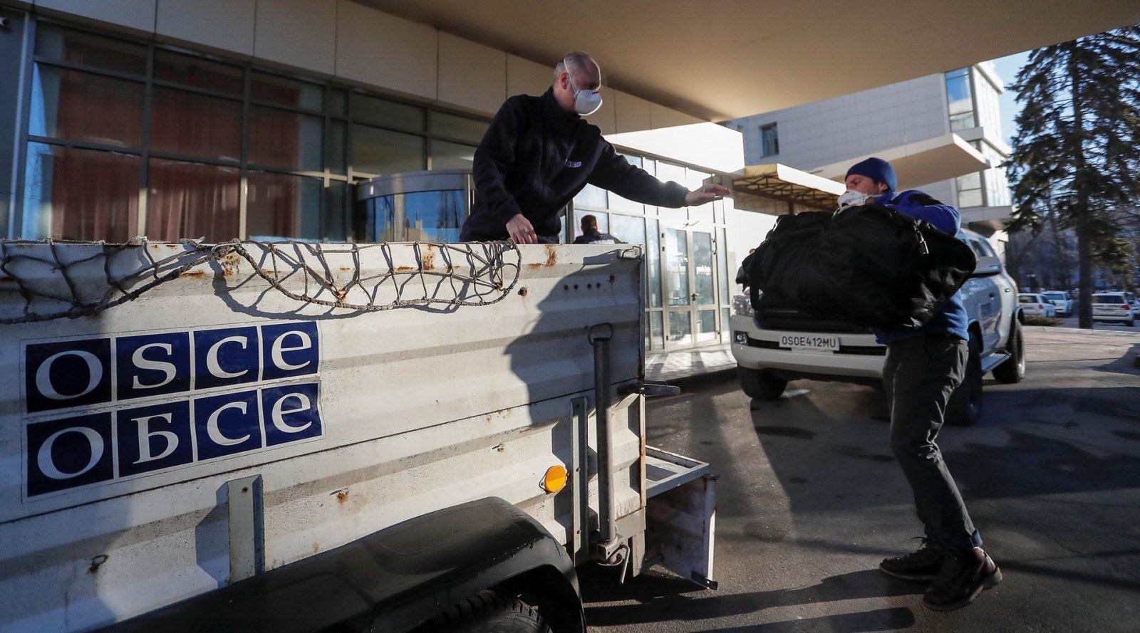 Members of the Organization for Security and Co-operation in Europe (OSCE) load luggage before leaving the Park Inn hotel housing the monitoring mission in the rebel-controlled city of Donetsk, Ukraine February 13, 2022. (REUTERS)