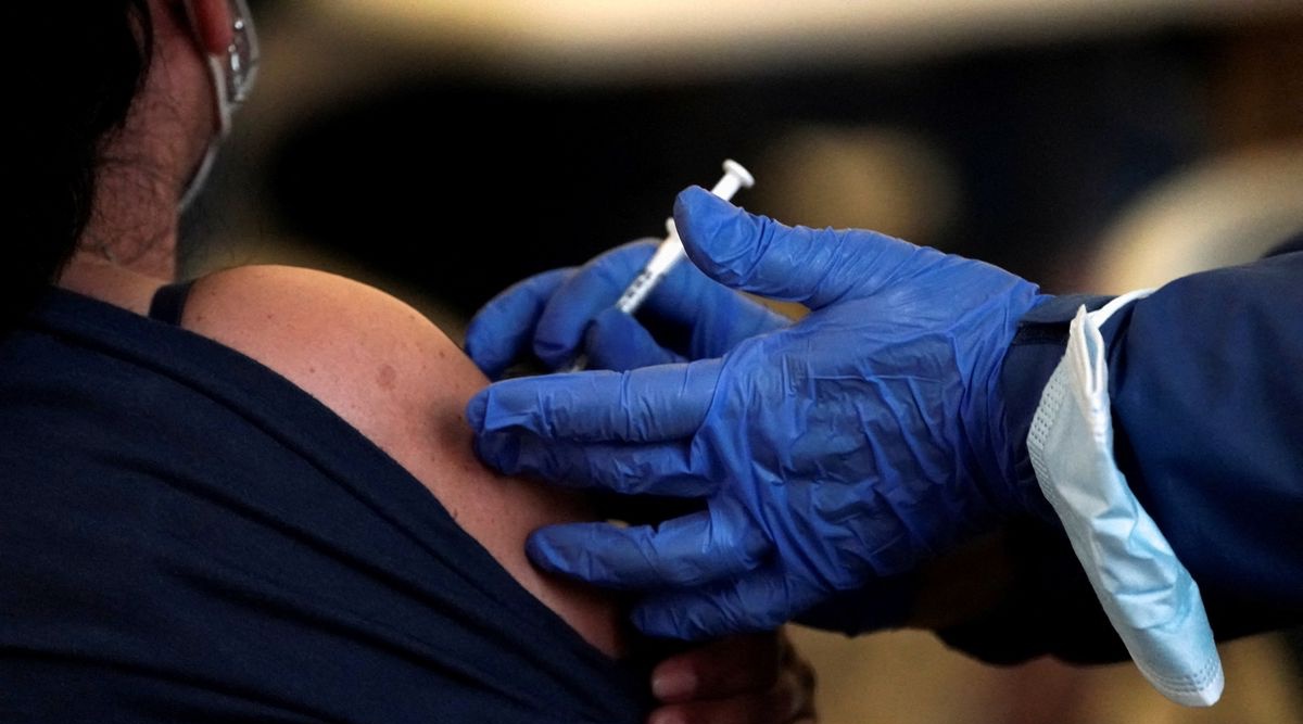 A Los Angeles County Department of Public Health worker administers a dose of a coronavirus disease (Covid-19) vaccine at a pop-up clinic at Tom Bradley International Terminal at Los Angeles International Airport, California, U.S. December 22, 2021. REUTERS/Bing Guan