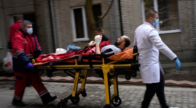 An injured man is wheeled on a stretcher at a local hospital in Novoiavorisk, western Ukraine, Sunday, March 13, 2022. (AP)