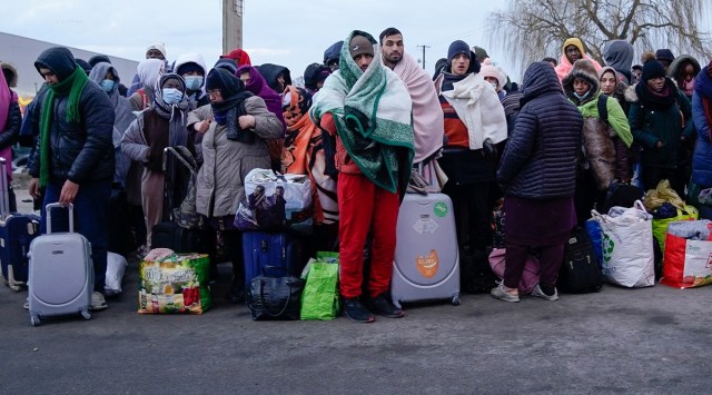People who have fled the Russian invasion in Ukraine wait to board a bus bound for a refugee centre established in Przemysl, in Medyka, Poland, February 28, 2022. (Reuters)