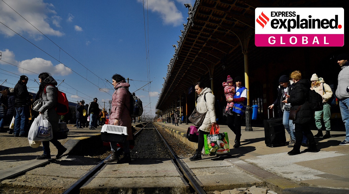 Refugees walk across train tracks to board a train to Bucharest at Suceava train station after fleeing Ukraine to the Siret border crossing in Romania. (Reuters)