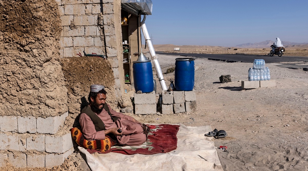 Hafiz Qadim waits for passing travellers to stop at his shop, which sells gas, water and snacks, along Highway 1 on the border of Kandahar and Zabul provinces in Afghanistan, December 9, 2021. (David Guttenfelder/The New York Times)