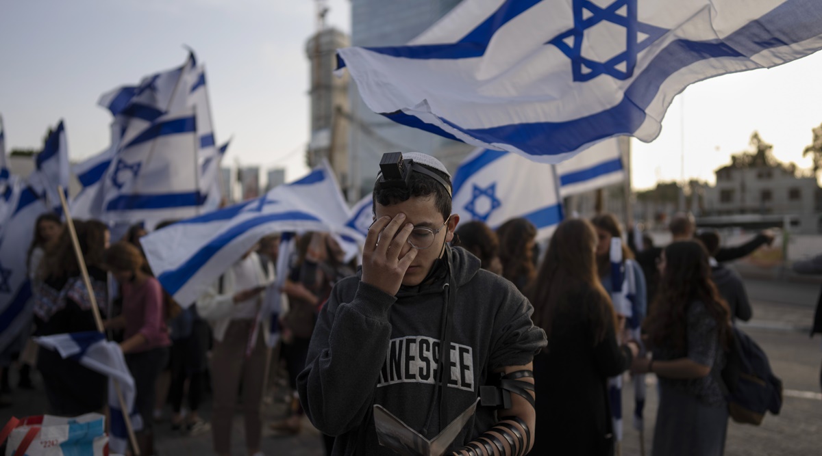An Israeli youth pray next to a right wing activists as they protest against Israel's Prime Minister Naftali Bennett, following a recent wave of violence, in Tel Aviv, Israel, Wednesday, March 30, 2022. (AP)