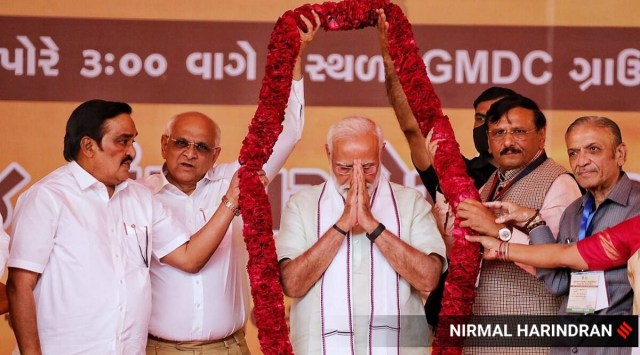 CM Bhupendra Patel and BJP state chief CR Paatil welcome PM Narendra Modi during Gujarat Panchayat Sammelan at the GMDC ground in Ahmedabad on Friday. (Express photo by Nirmal Harindran) 