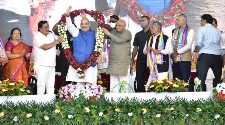 Union Minister Amit Shah, Gujarat Chief Minister Bhupendra Patel and state BJP president CR Paatil at Sankalp thi Samruddhi in Tapi Sunday. (Express Photo)