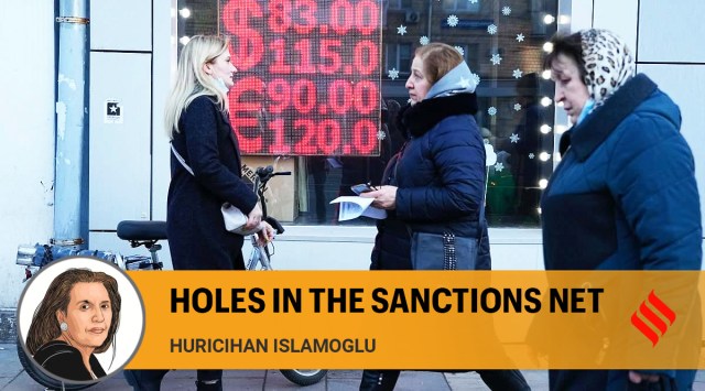 People walk past a currency exchange office screen displaying the exchange rates of U.S. Dollar and Euro to Russian Rubles in Moscow's downtown, Russia, Monday, Feb. 28, 2022. (AP Photo)