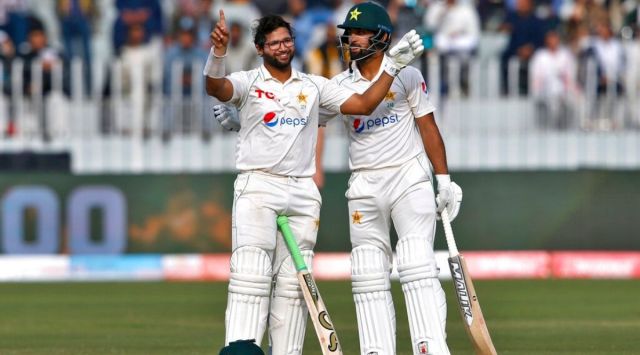 Pakistan's Imam-ul-Haq, left, celebrates after completing a century while teammate Abdullah Shafique watches during the 5th day of the first test match between Pakistan and Australia at the Pindi Stadium, in Rawalpindi, Pakistan, Tuesday, March 8, 2022. (AP Photo/Anjum Naveed)