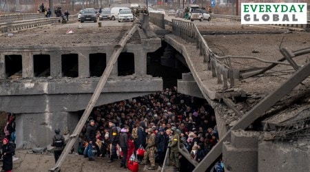 Ukrainians crowd under a destroyed bridge as they try to flee across the Irpin River in the outskirts of Kyiv. (AP)