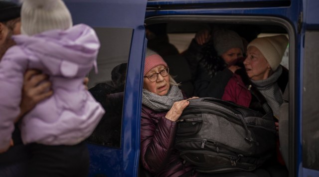 Ukrainian women sit inside a van as artillery echoes nearby, as people flee Irpin on the outskirts of Kyiv, Ukraine, Monday, March 7, 2022. (AP Photo/Emilio Morenatti)
