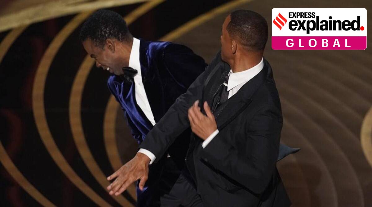 Will Smith, right, hits presenter Chris Rock on stage while presenting the award for best documentary feature at the Oscars on Sunday, March 27, 2022, at the Dolby Theatre in Los Angeles. (AP)
