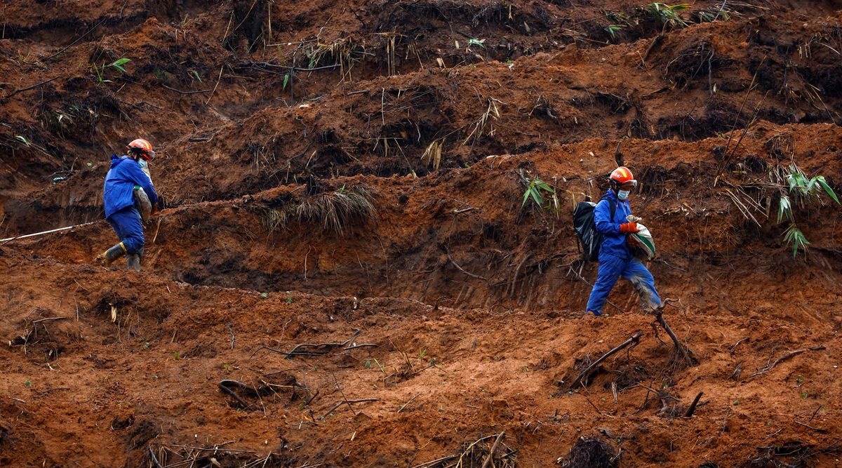 Rescue workers walk at the site where a China Eastern Airlines Boeing 737-800 plane flying from Kunming to Guangzhou crashed, in Wuzhou, Guangxi Zhuang Autonomous Region, China March 24, 2022. REUTERS/Carlos Garcia Rawlins/File Photo