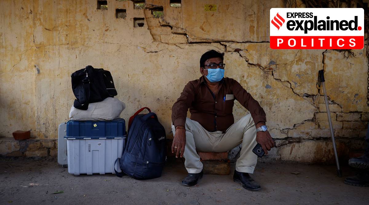 A polling officer sits next to electronic voting machine (EVM) after collecting it from a distribution centre ahead of the last phase of state assembly elections in Varanasi. (Source: REUTERS)