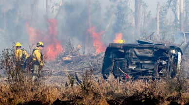 Florida Forest Service crew members wait for heavy machinery as a new hot spot flares in the Adkins Avenue Fire in Panama City, March 6, 2022. (AP)