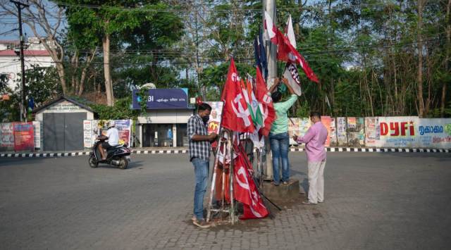 Strike supporters erect flags at a traffic intersection on the first day of two day nationwide strike called by various labor unions in Kochi, Kerala, Monday, March 28, 2022. (AP Photo)