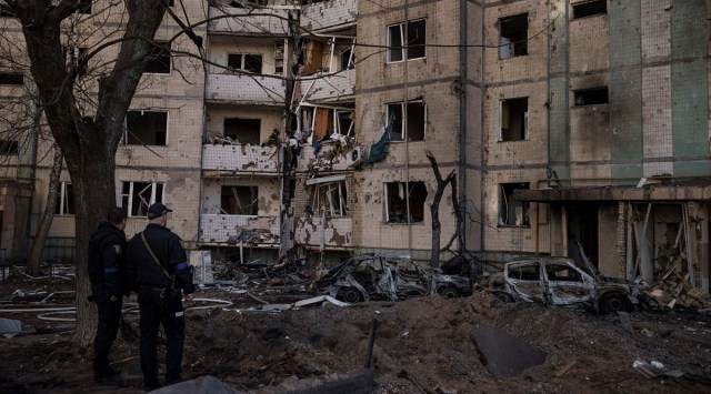 Ukrainian policemen look at a heavily damaged building after bombing in Kyiv (AP/Felipe Dana)