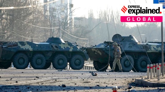 A soldier walks along Ukrainian armored vehicles blocking a street in Kyiv, Ukraine. (AP)