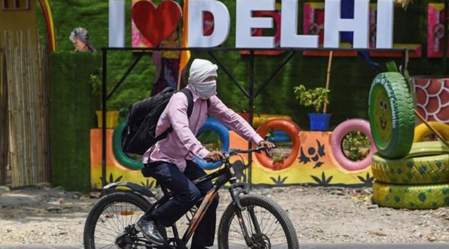 A man shields his face from the heat with a cloth while riding a bicycle, in New Delhi, Sunday, May 1, 2022. (PTI)