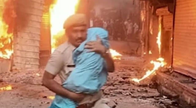 Constable Netresh Sharma saving a child from a burning house in Karauli. (Twitter/@SukirtiMadhav)