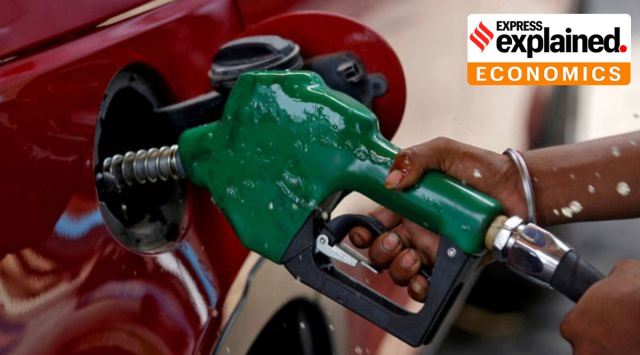 A worker holds a nozzle to pump petrol into a vehicle at a fuel station in Mumbai. (Reuters Photo/Francis Mascarenhas, File)